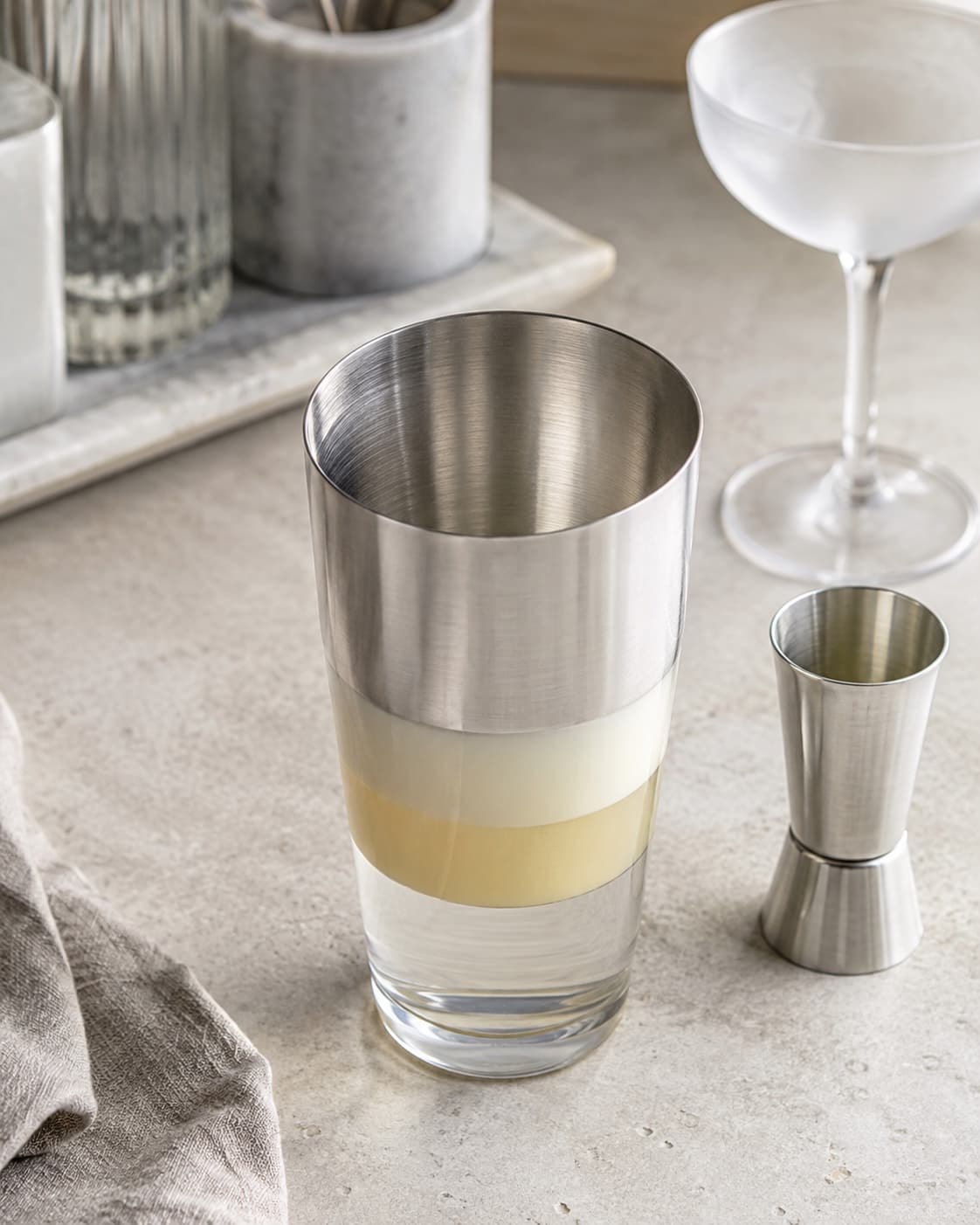 Gin, lys kakaolikør og fløde målt lagvis i en åben shaker