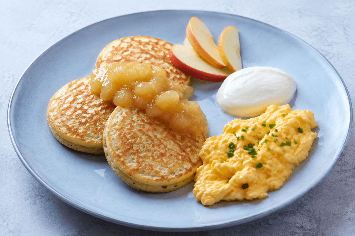 Tre små brunchpandekager med æblekompot, ahornskyr, friske æblebåde og bløde røræg med purløg