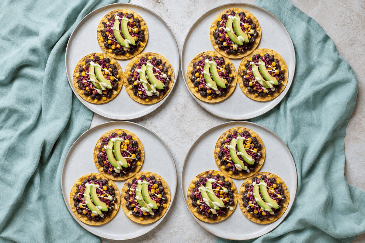 Fire tallerkener med ovnbagte tostadas med sorte bønner og avocado-kålslaw