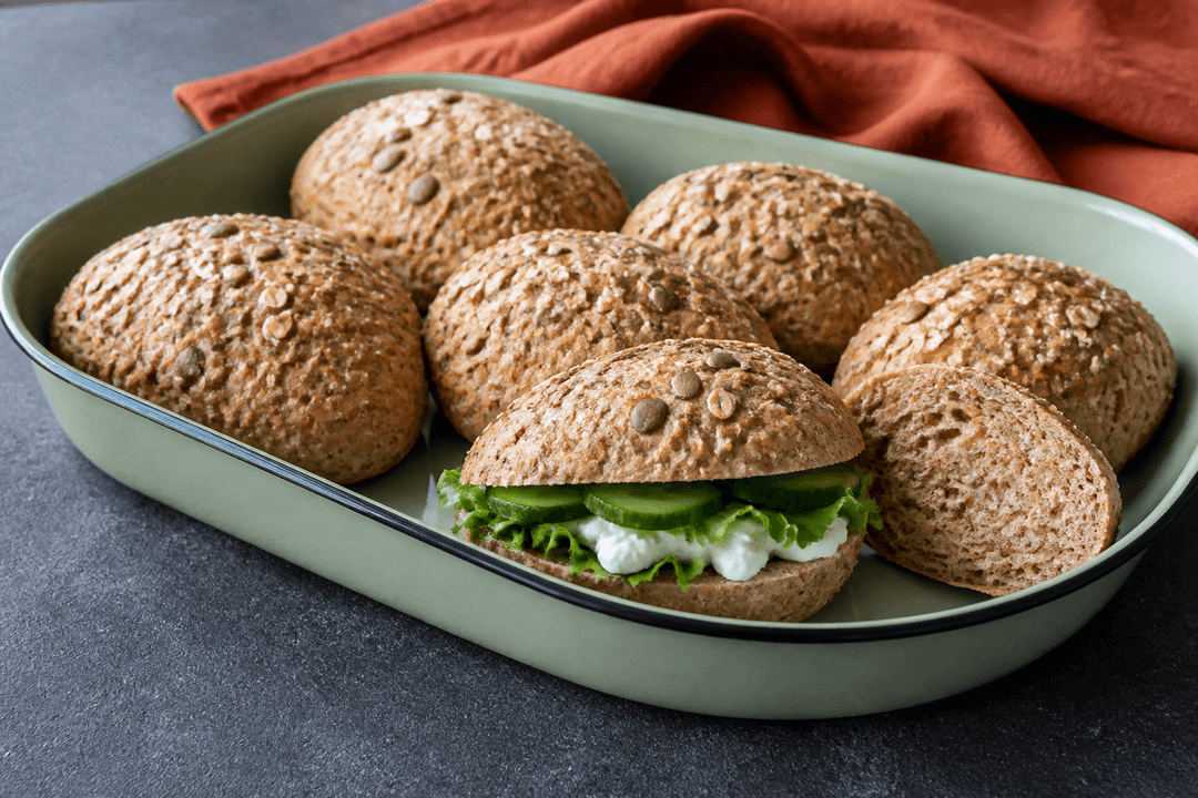 Gyldne kerneboller med hytteost, gulerod og rug i salviegrøn emaljeform samt én fyldt madpakkebolle med salat, agurk og ost