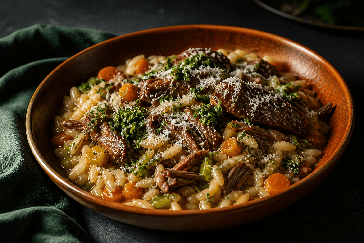 Cremet orzo med store stykker rødvinsbraiseret lam, gulerod, selleri, hård ost og citron-persillegremolata i brændt orange skål