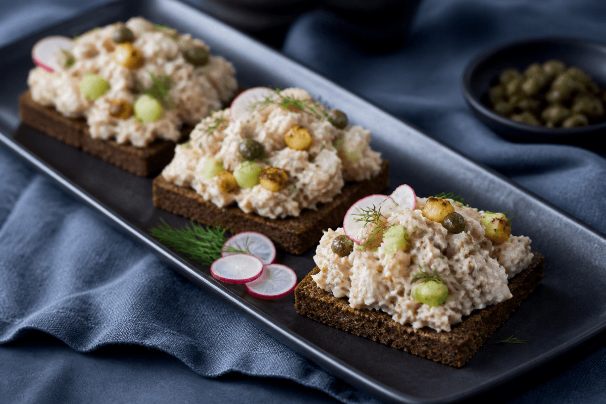 Nordisk tunsalat med bagt selleri, æble, kapers og dild på tre små stykker ristet rugbrød
