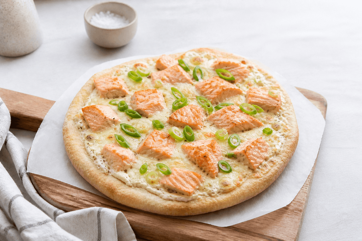 Pizza med laks og wasabi anrettet i Madblikkets lyse nordiske billedstil med rettens vigtigste råvarer tydeligt synlige