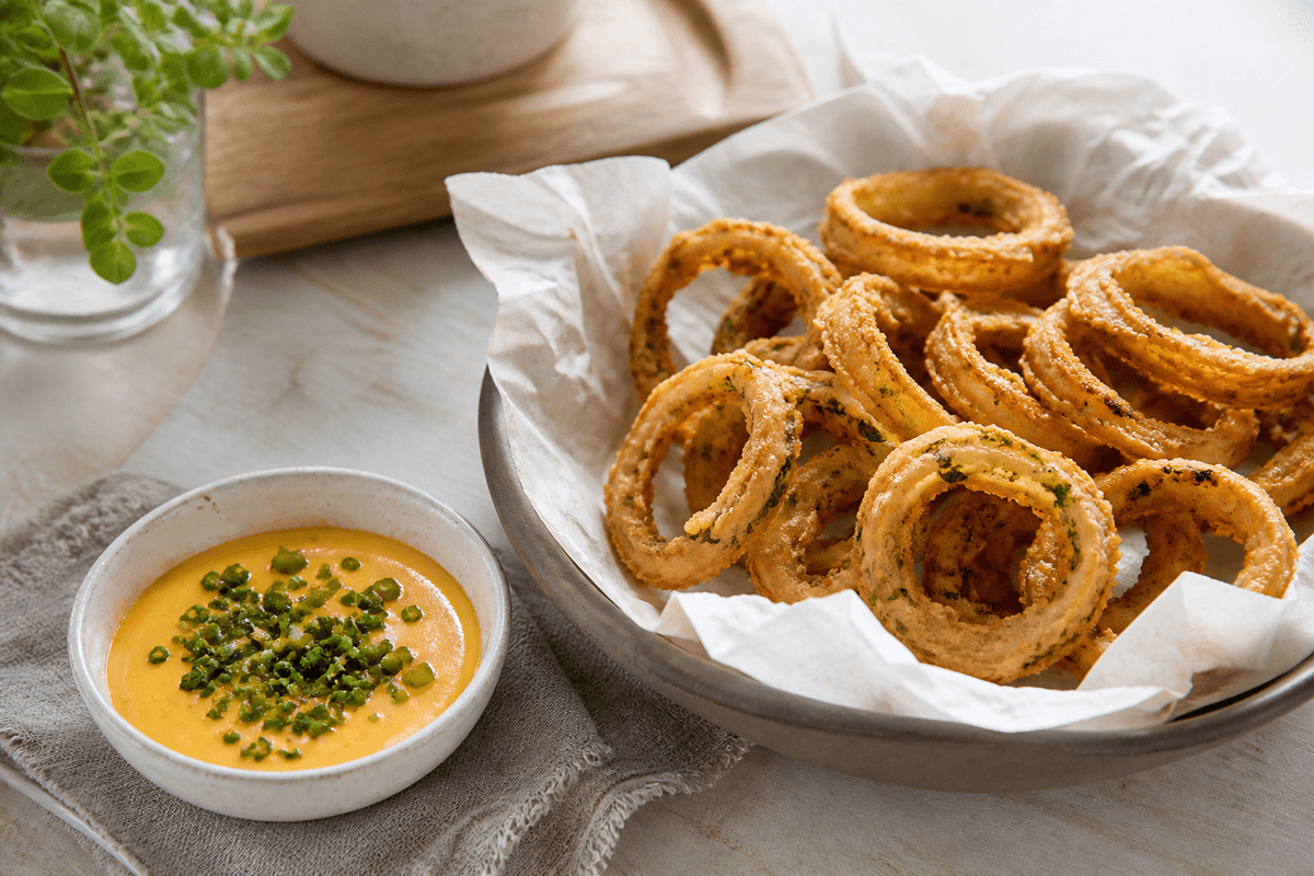 Sprøde løgringe med chilicheese dip anrettet i Madblikkets lyse nordiske billedstil