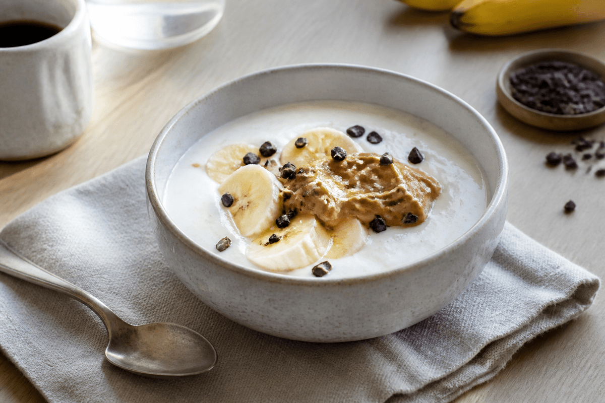 Frugtyoghurt med banan, peanutbutter og kakaonibs anrettet i Madblikkets lyse nordiske billedstil