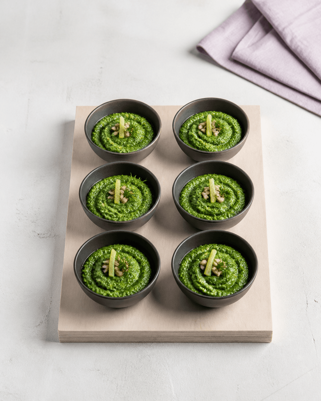 Seks mørke skåle i to gange tre på birkebræt med grøn dildpesto, citron, solsikkekerner og dildtop