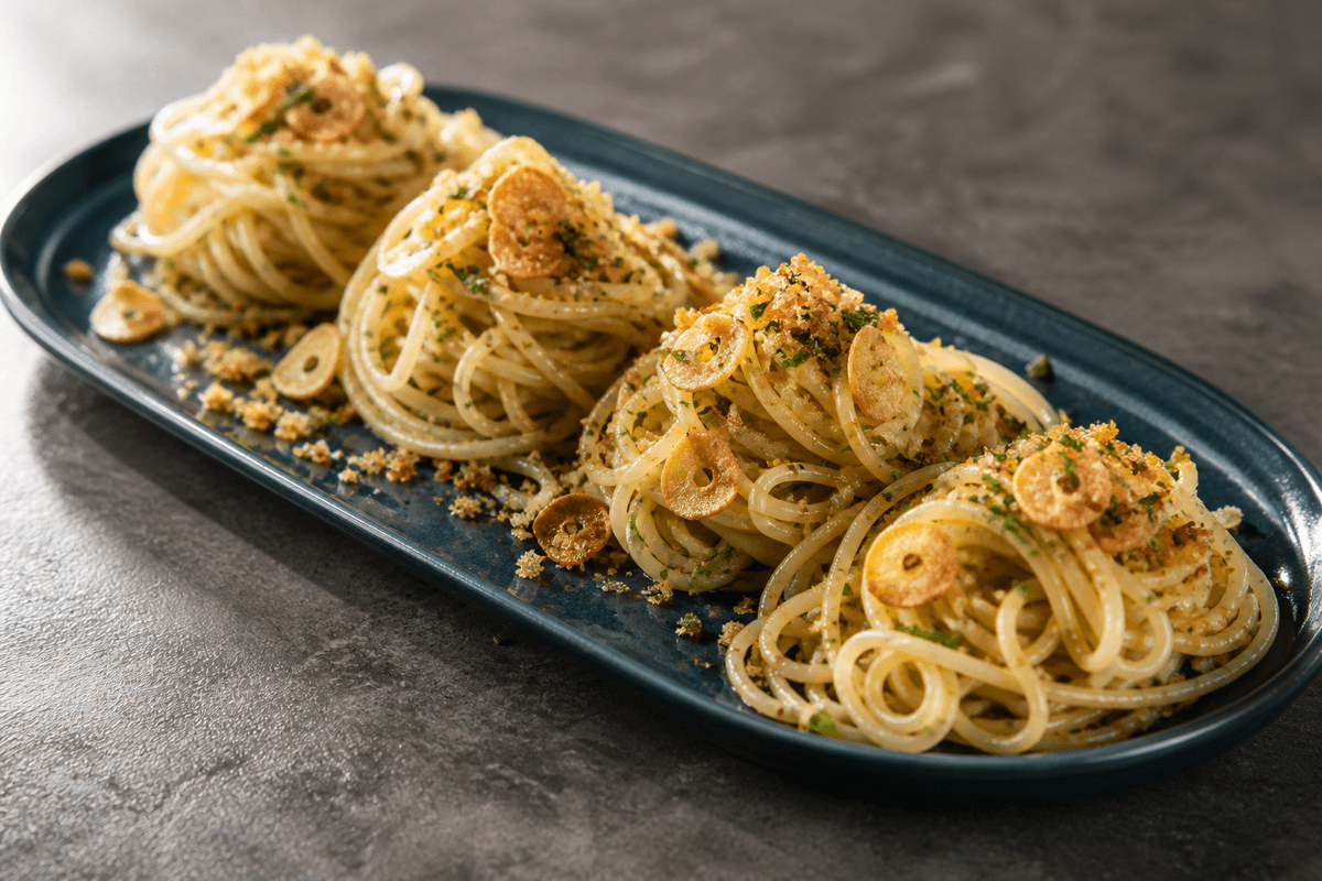 Spaghetti aglio e olio med ristet hvidløg og citron anrettet i Madblikkets lyse nordiske billedstil med rettens vigtigste råvarer tydeligt synlige