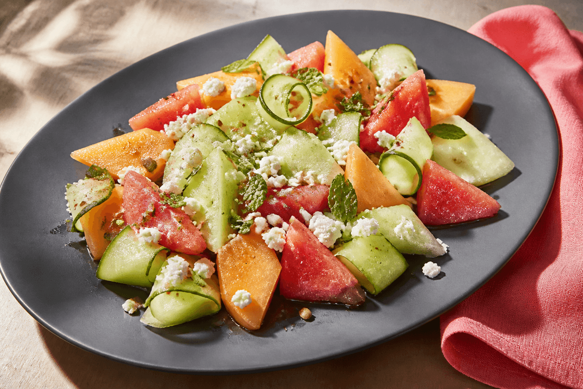 Melonsalat med chili, mynte, feta og græskarkerner anrettet i Madblikkets lyse nordiske billedstil med rettens vigtigste råvarer tydeligt synlige