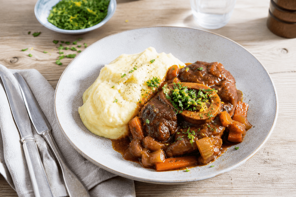 Osso buco med kartoffelmos og gremolata anrettet i Madblikkets lyse nordiske billedstil med rettens vigtigste råvarer tydeligt synlige