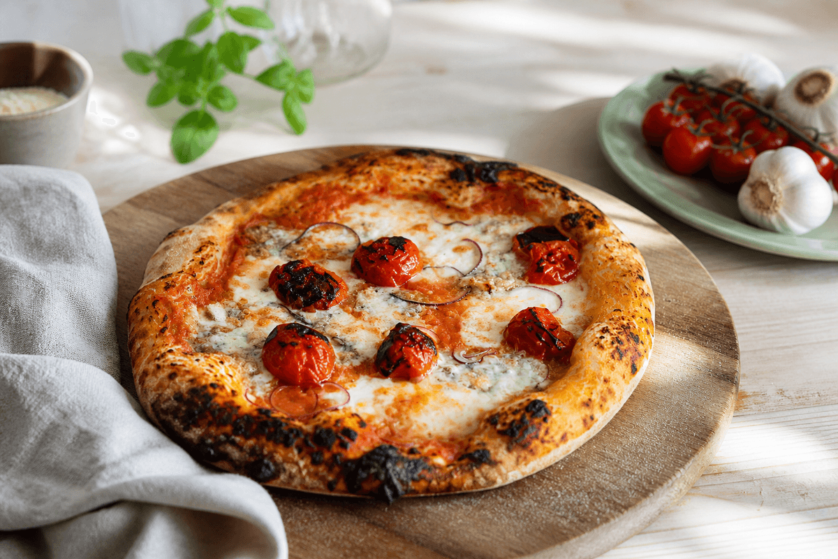 Surdejspizza anrettet i Madblikkets lyse nordiske billedstil med rettens vigtigste råvarer tydeligt synlige