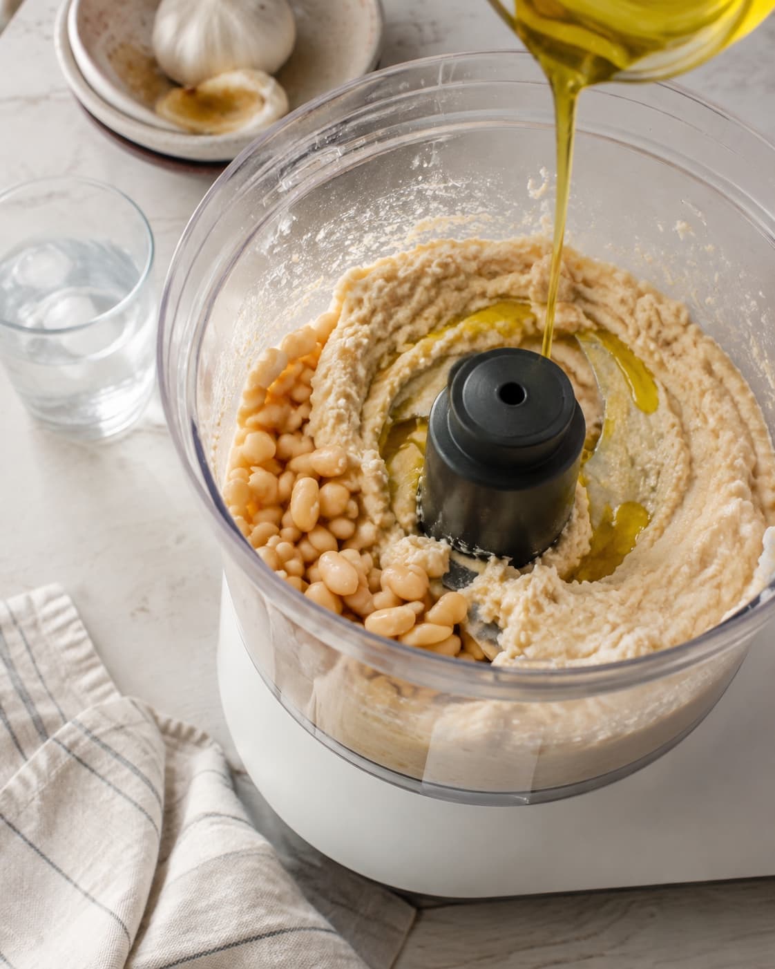 Hvide bønner, bagt hvidløg, citron og yoghurt blendes med olie og lidt isvand ad gangen