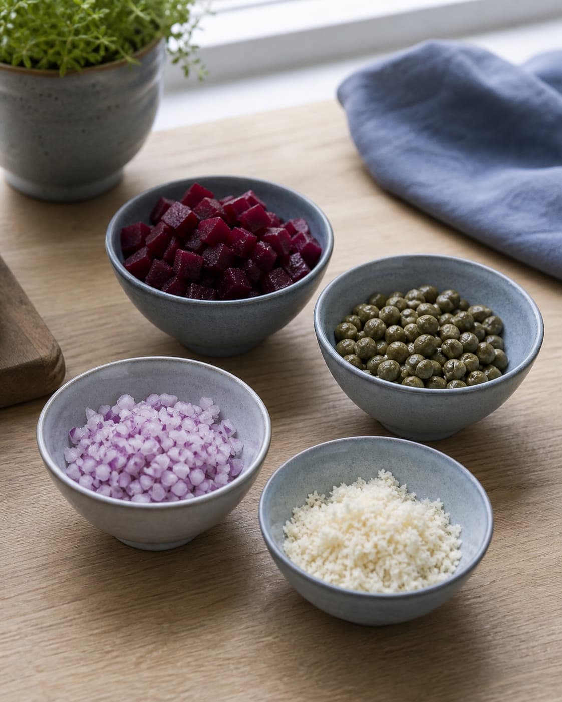 rødbedetern, kapers, finthakket rødløg og revet peberrod står tørre i fire separate kolde skåle; kontroltegnet er alle toppings er tørre, kolde og tydeligt adskilte