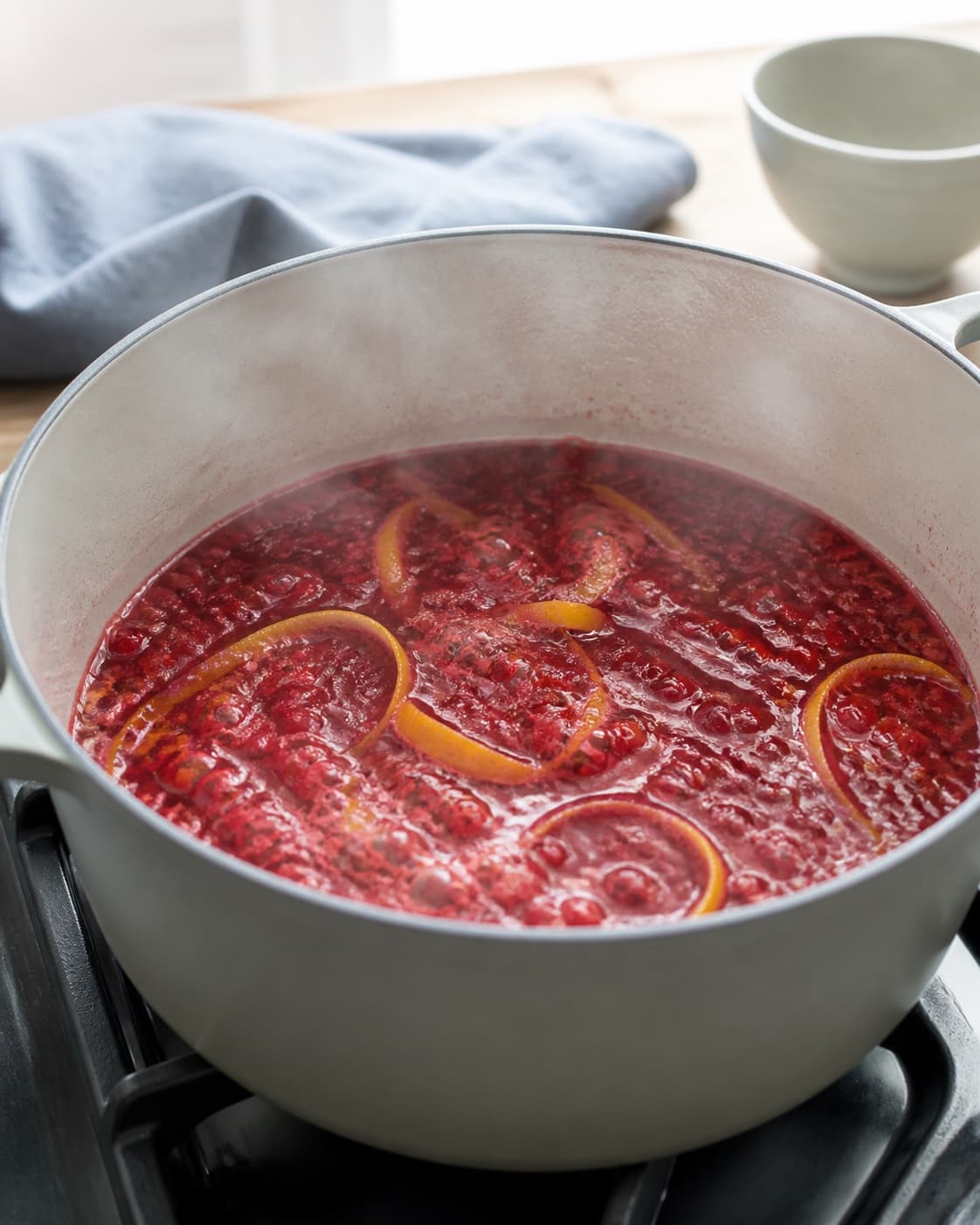 røde ribs og brede gule citronskalstrimler koger grundigt i klar dybrød væske med damp; kontroltegnet er alle bær er bristede i en klar dybrød væske uden tørre klaser