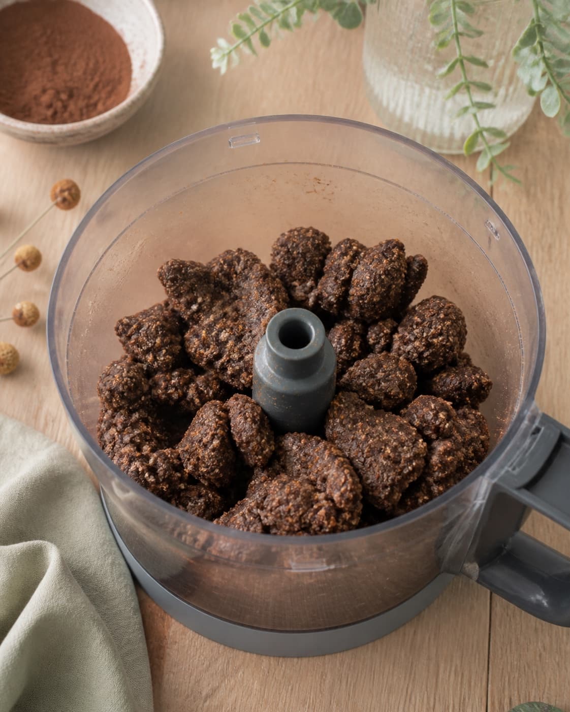 fast mørkebrun konfektmasse med fine havre- og mandelprikker samler sig i grove klumper i en åben foodprocessor uden løst pulver; kontroltegnet er massen er ensartet mørkebrun og fast, samler sig i grove klumper og efterlader ingen fri kaffe eller smeltet smør