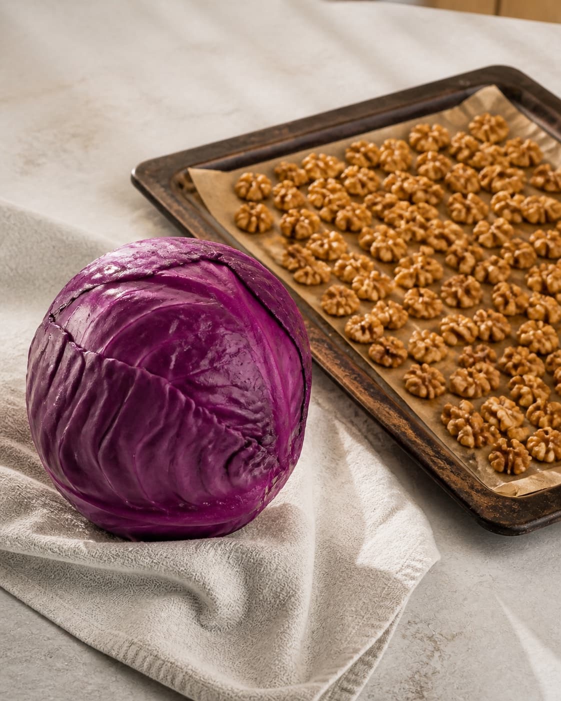 Clean dry red cabbage beside freshly toasted walnuts cooling on a tray under tilberedningen af rødkålssalat med æble