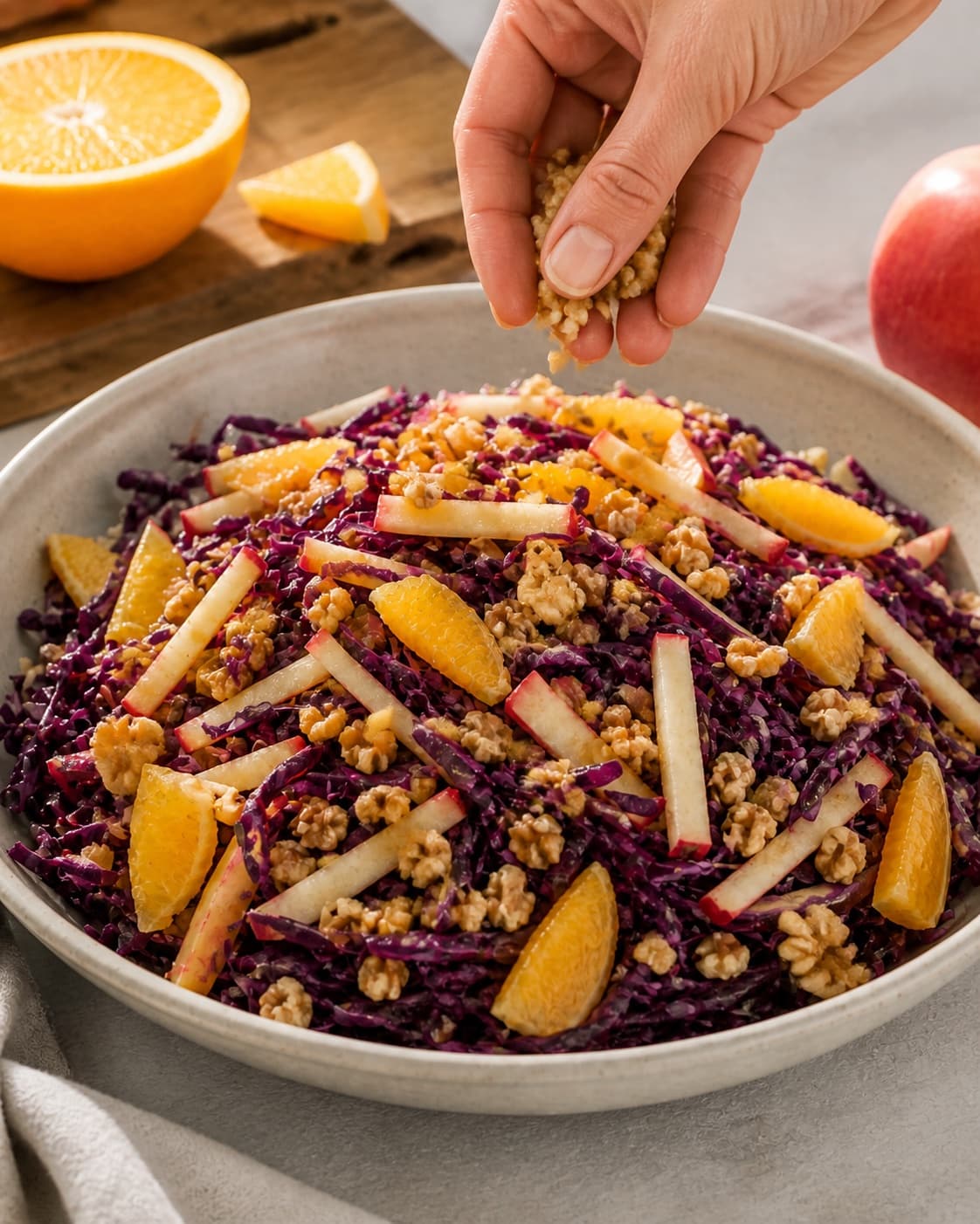 Finished red cabbage apple orange salad topped with crisp toasted walnuts under tilberedningen af rødkålssalat med æble