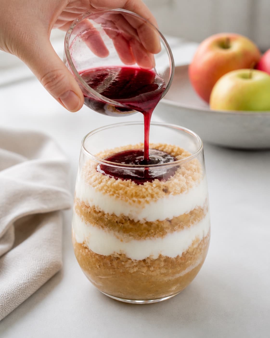 Layered Danish apple dessert with apple compote toasted breadcrumbs whipped cream and redcurrant jelly under tilberedningen af gammeldags æblekage med ristet rasp og flødeskum