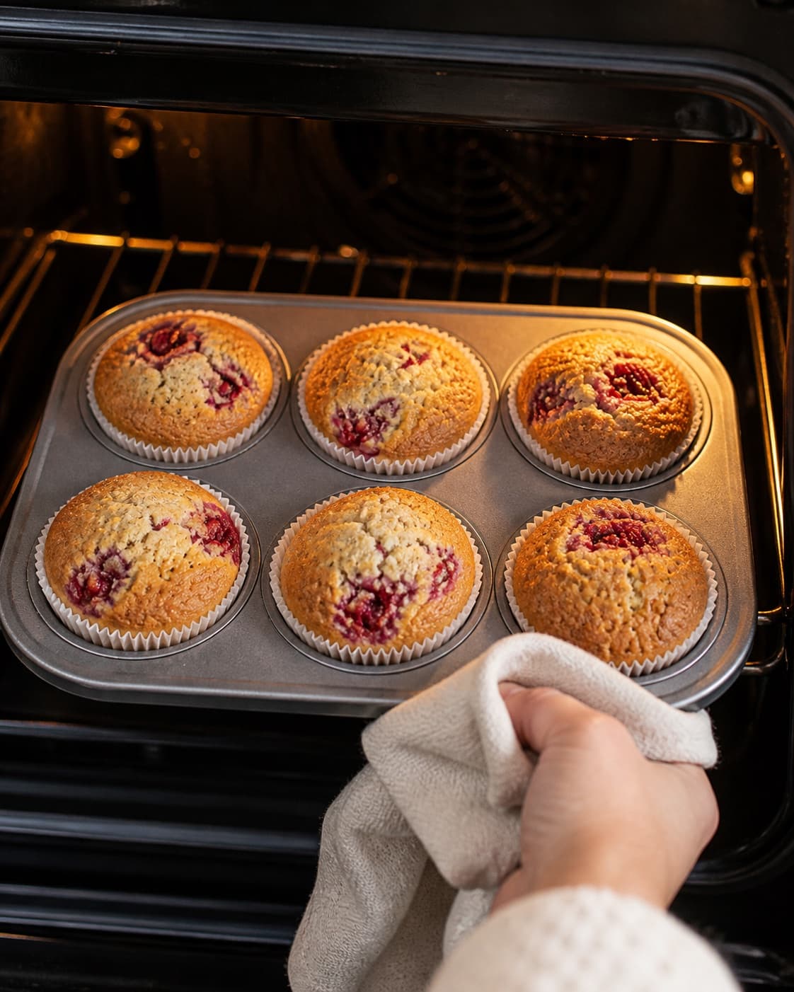 Raspberry muffins baking until domed and golden with set centres under tilberedningen af hindbærmuffins