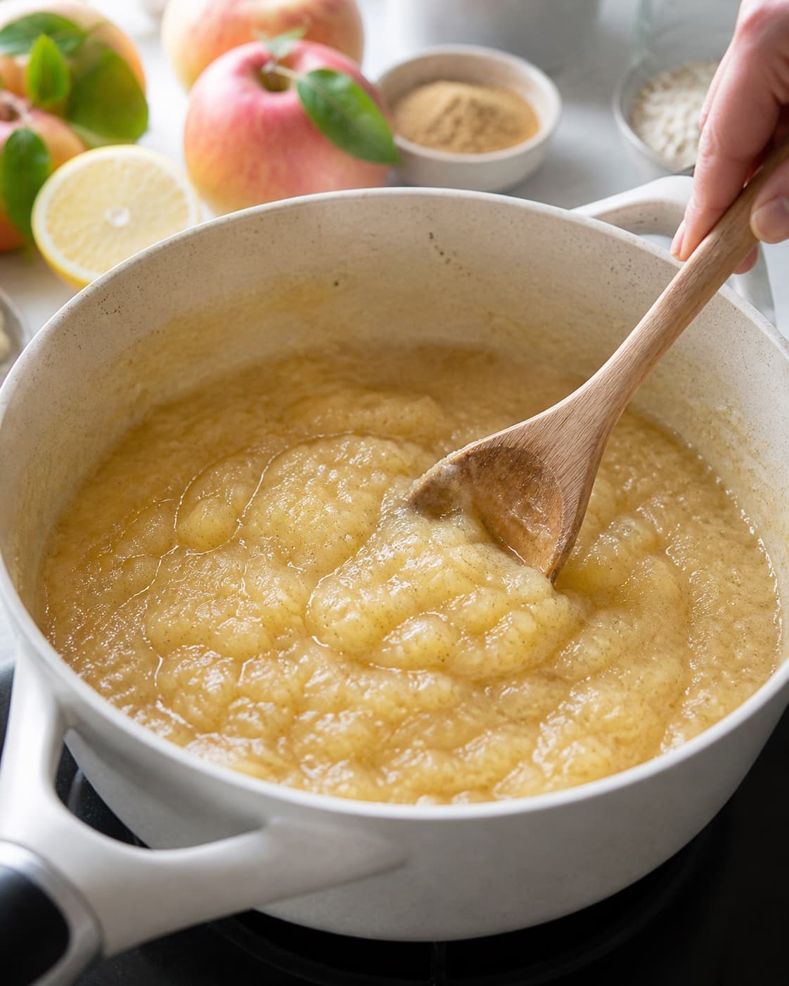 Apple porridge simmering gently with part of the fruit mashed and part still visible under tilberedningen af æblegrød