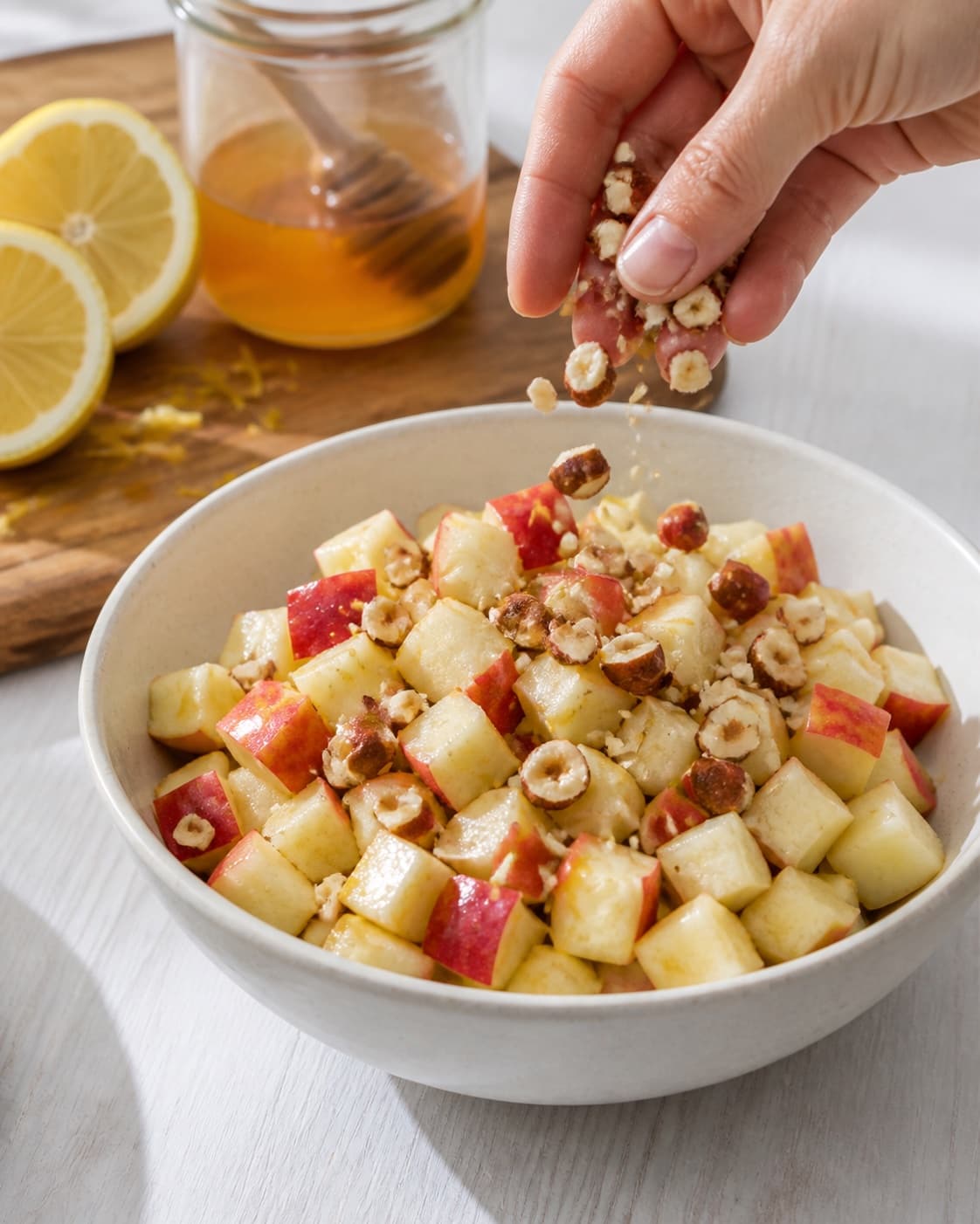 Marinated apple cubes topped at the last moment with chopped toasted hazelnuts under tilberedningen af æbletern i citron og honningmarinade