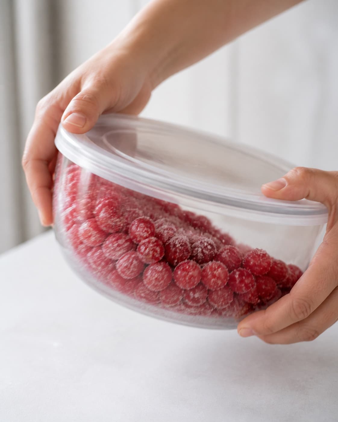 Lidded bowl of redcurrants being gently shaken to coat berries without crushing under tilberedningen af rysteribs