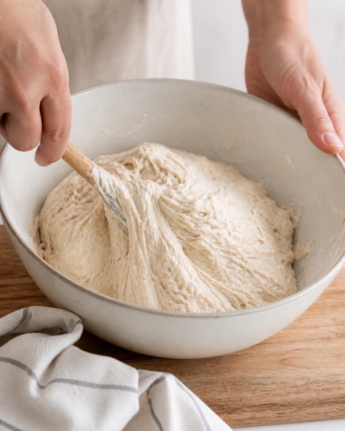 Flour warm water yeast and salt being mixed into soft pizza dough under tilberedningen af pizza med laks og wasabi
