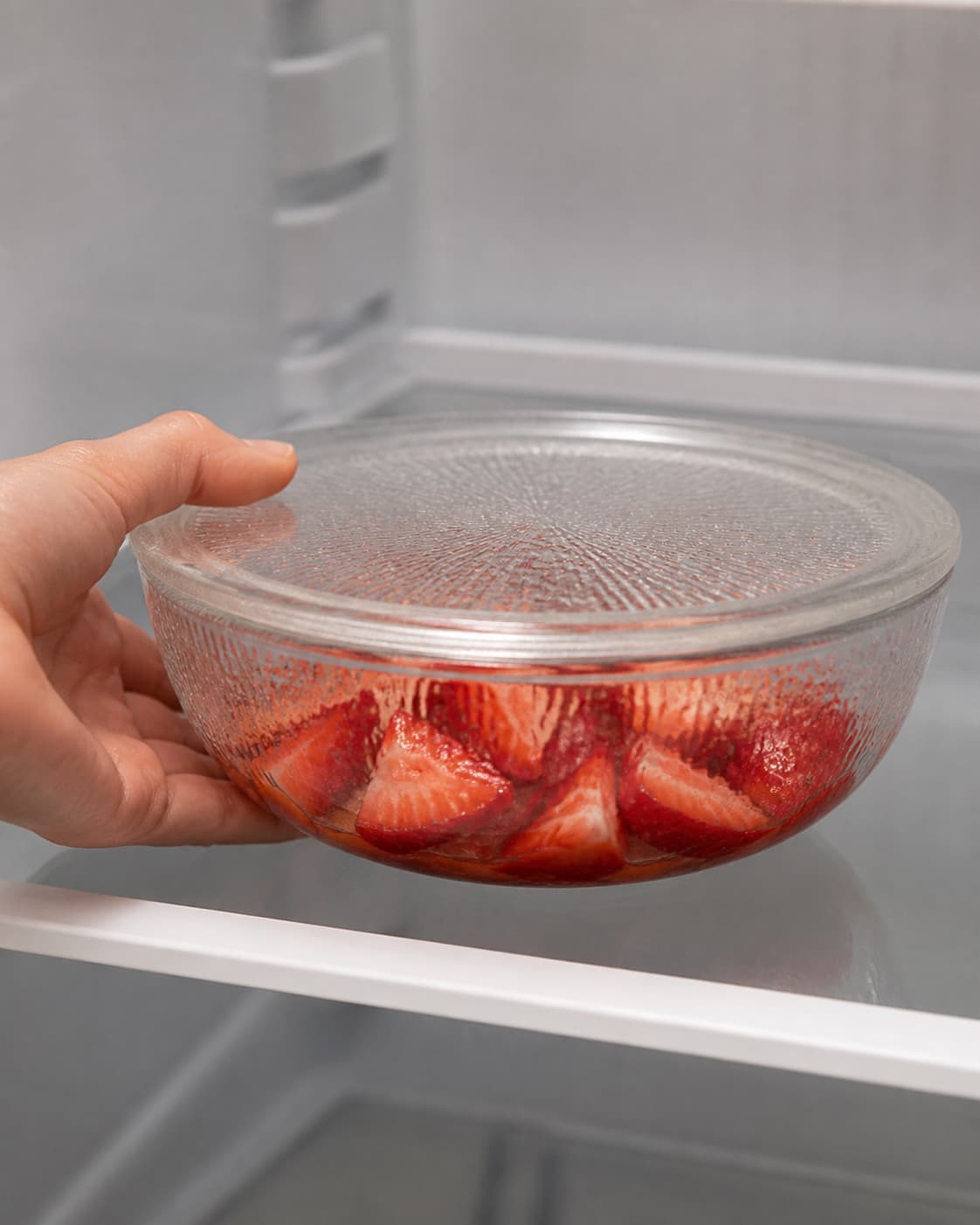 Macerated strawberry quarters resting cold while retaining their shape under tilberedningen af jordbærdessert med mynte