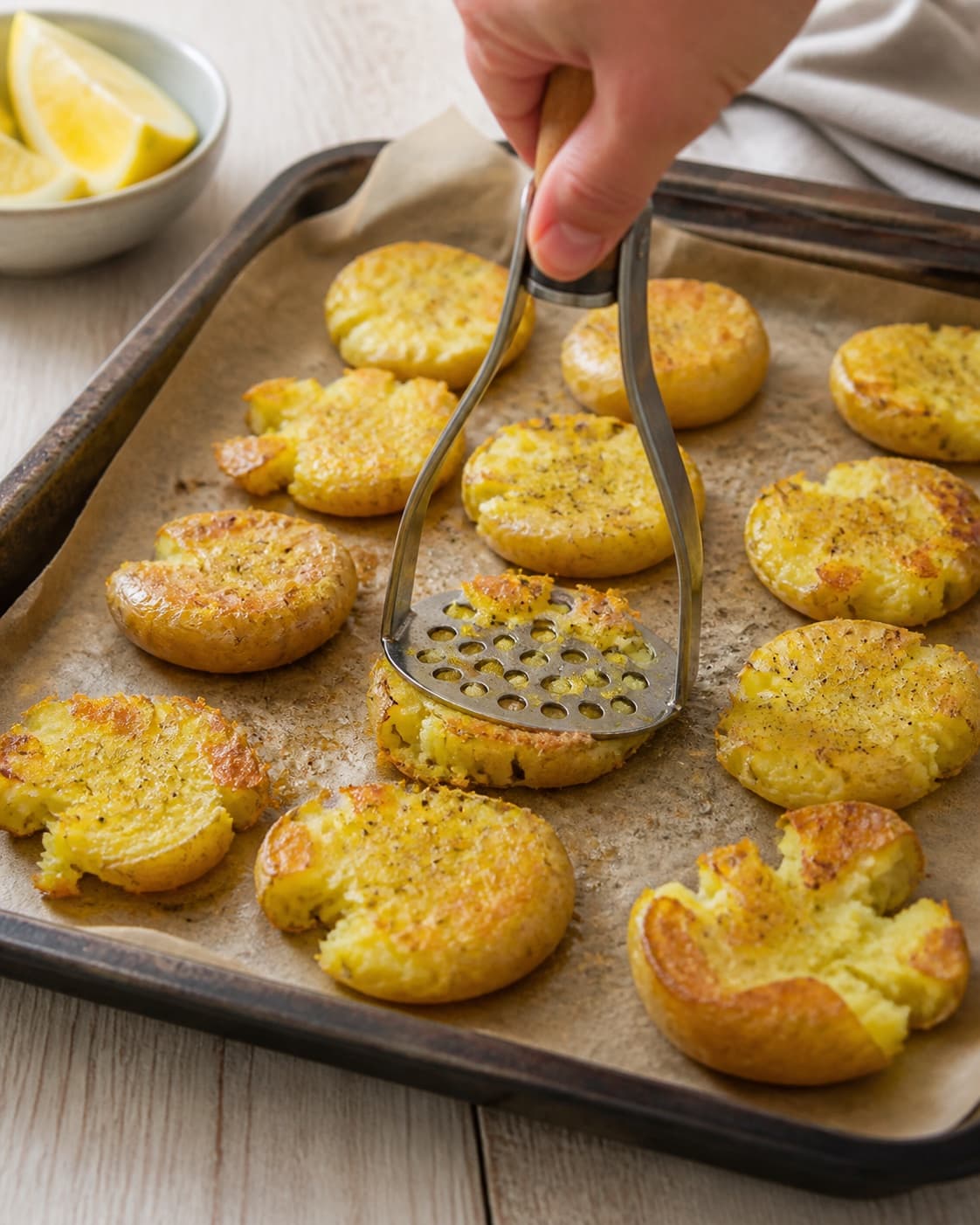 Smashed potatoes roasting until their jagged edges turn deep golden under tilberedningen af knuste kartofler med stenbiderrogn