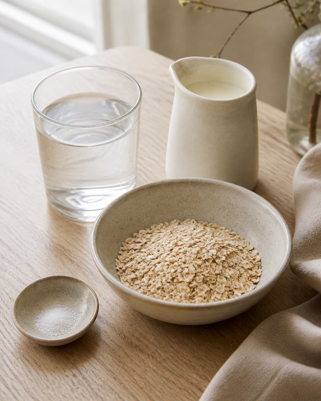 Coarse oats milk water salt diced apples cinnamon and chopped almonds measured separately under tilberedningen af havregrød
