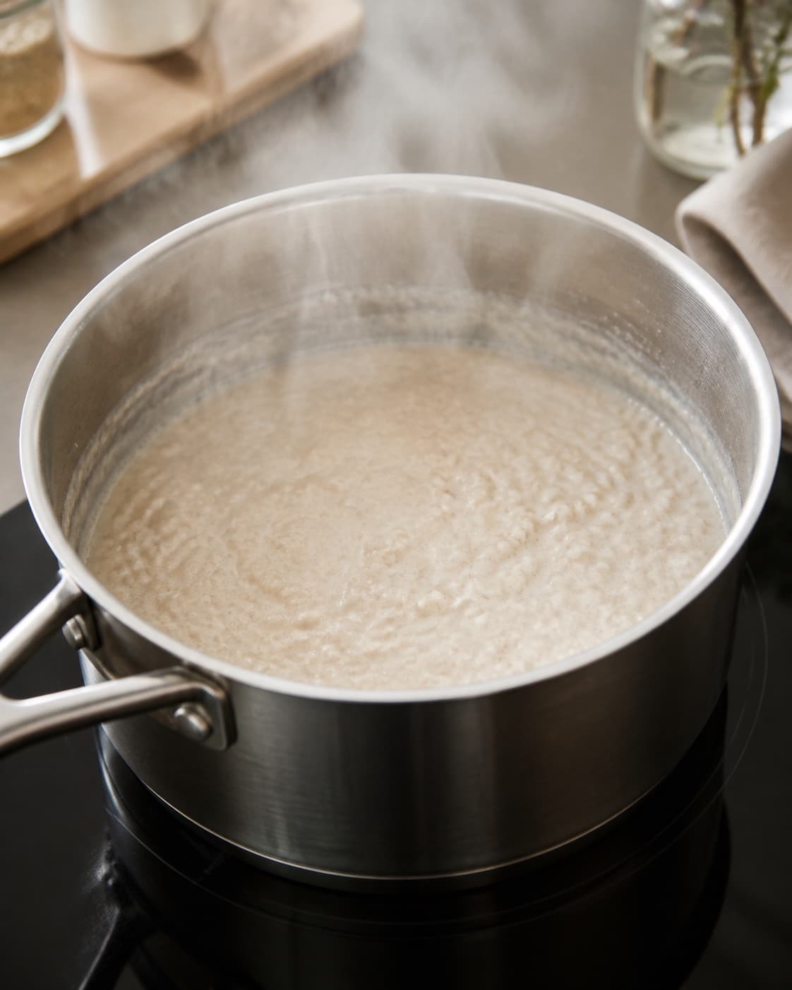 Coarse oats and water beginning to steam evenly in a heavy saucepan under tilberedningen af havregrød