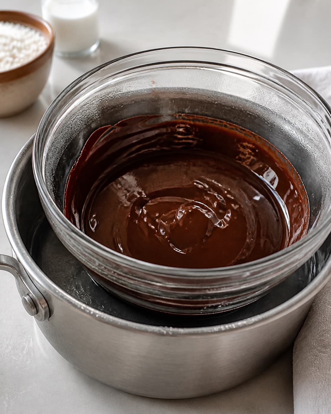 Dark chocolate melting gently over a water bath before coconut oil is stirred in under tilberedningen af bounty