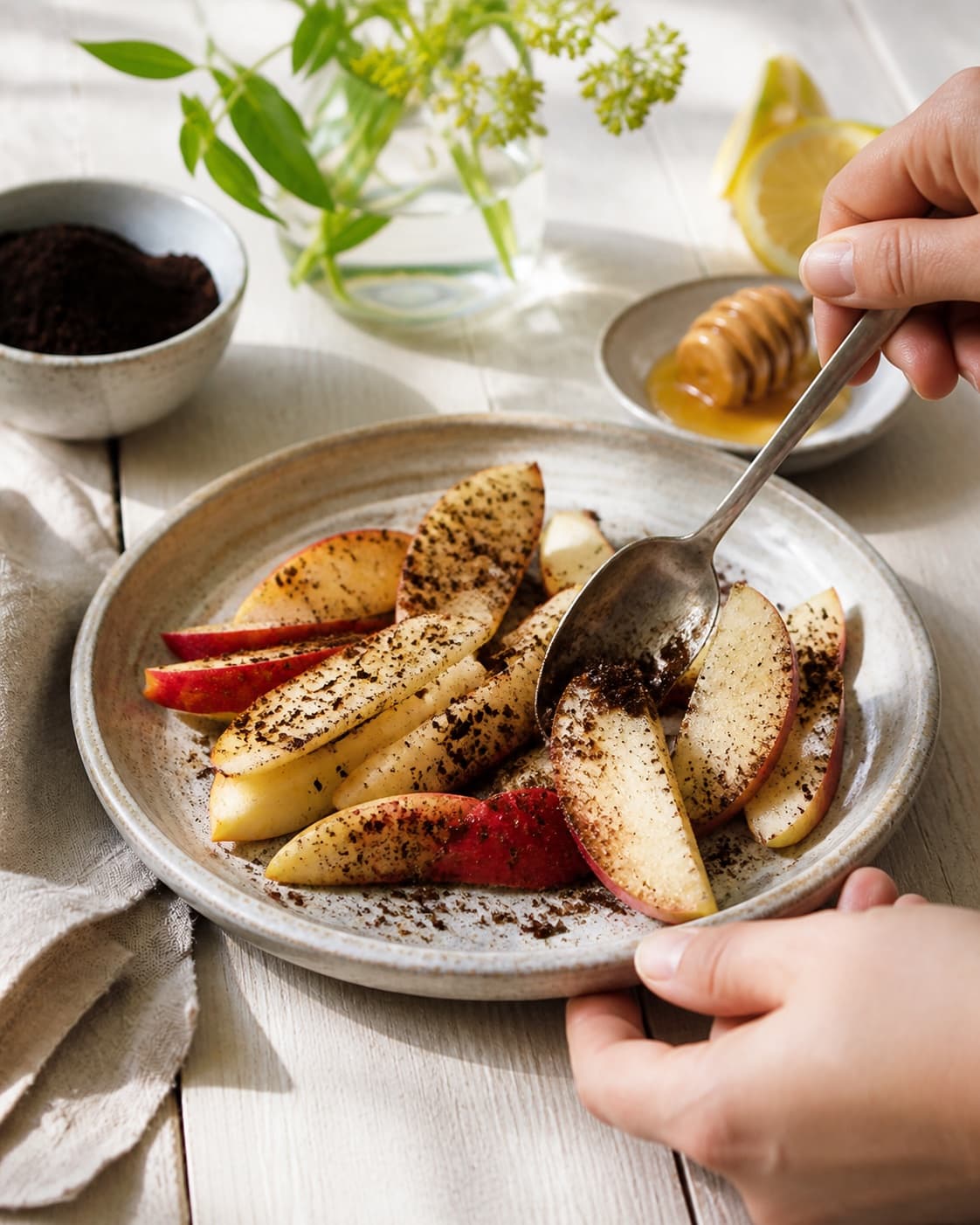 Apple wedges being gently coated in a thin glossy honey liquorice dressing under tilberedningen af æbler med lakrids
