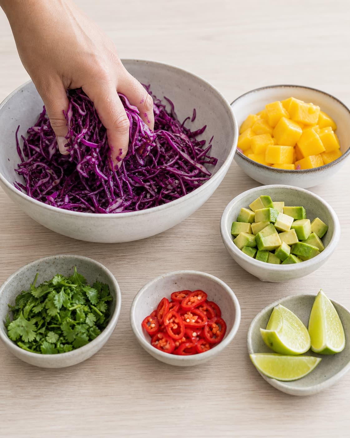 Finely shredded lime cabbage beside neat mango avocado coriander and chilli pieces under tilberedningen af tortilla med laks og mango