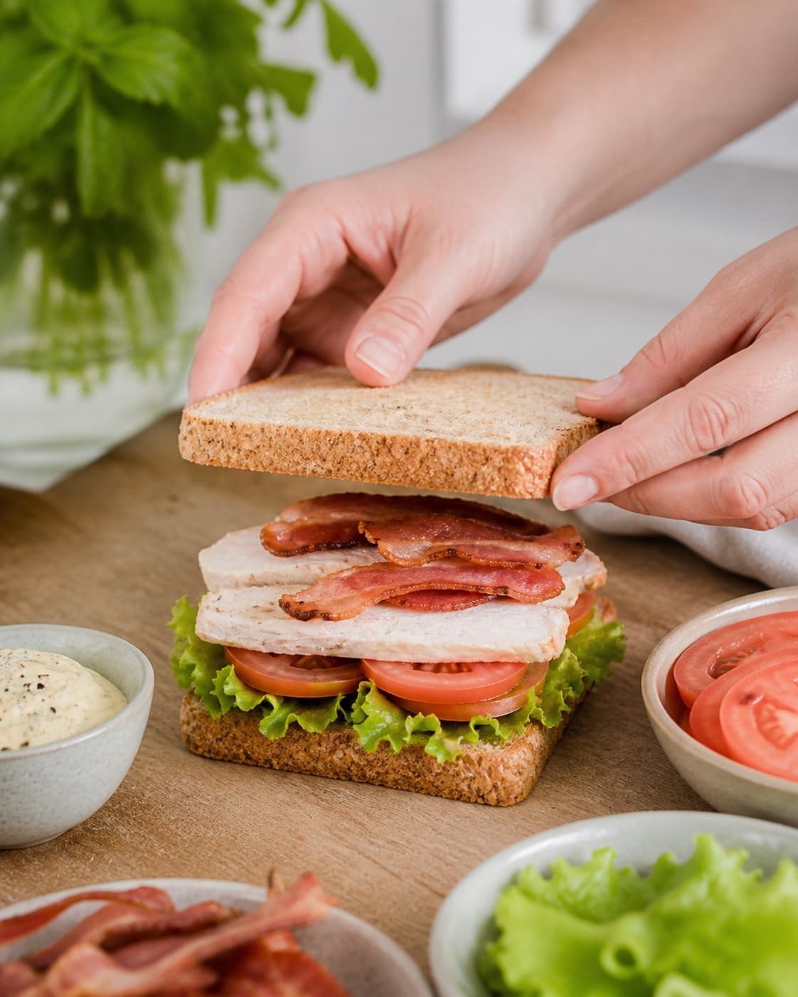 Triple decker club sandwiches layered with lettuce chicken tomato bacon cucumber and mustard mayonnaise under tilberedningen af clubsandwich med mørt kyllingekød og bacon