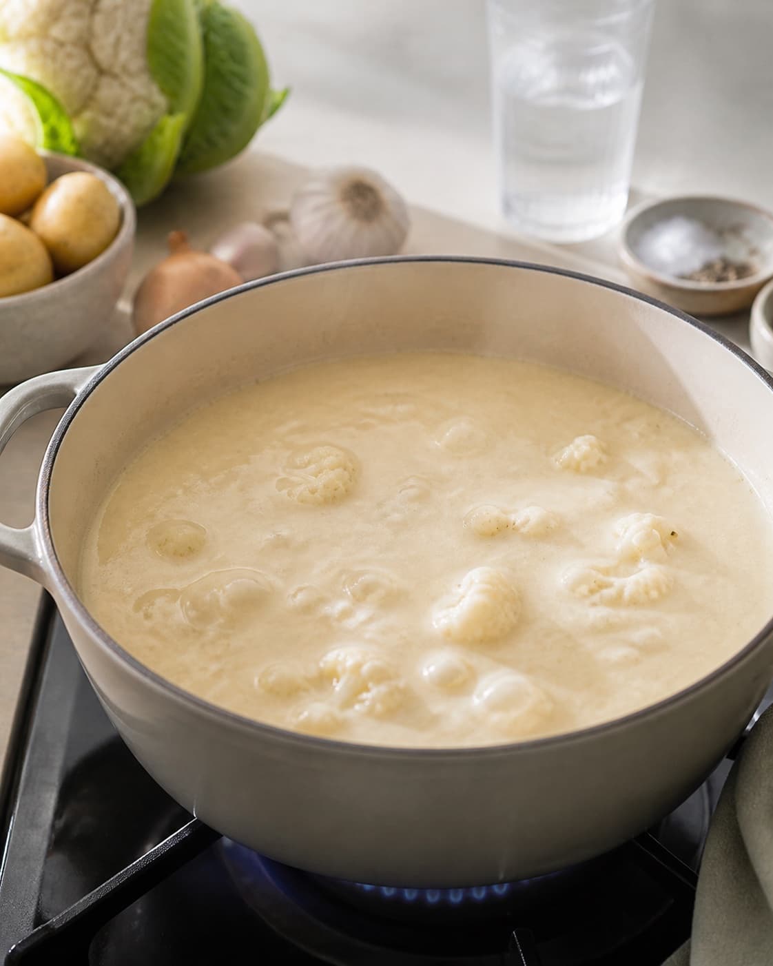 Cauliflower and potato simmering gently in vegetable stock until fully tender under tilberedningen af blomkålssuppe