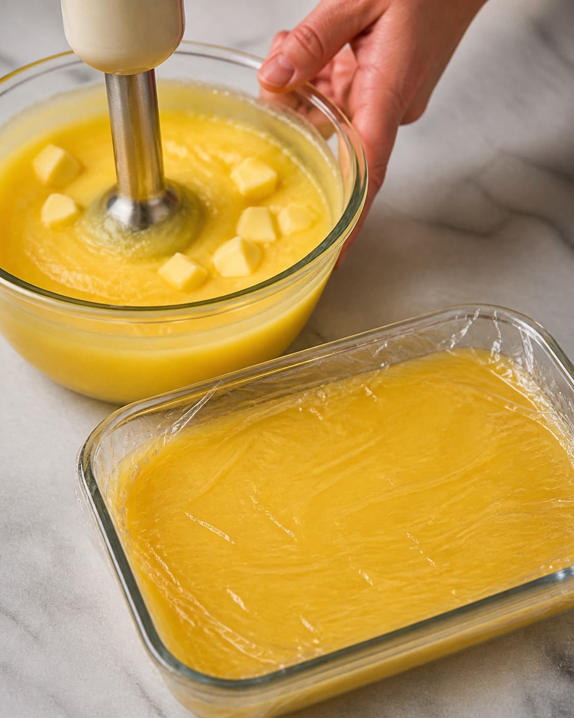 Cold butter blended into strained lemon curd before rapid chilling under contact film under tilberedningen af silkeblød lemoncurd med citron