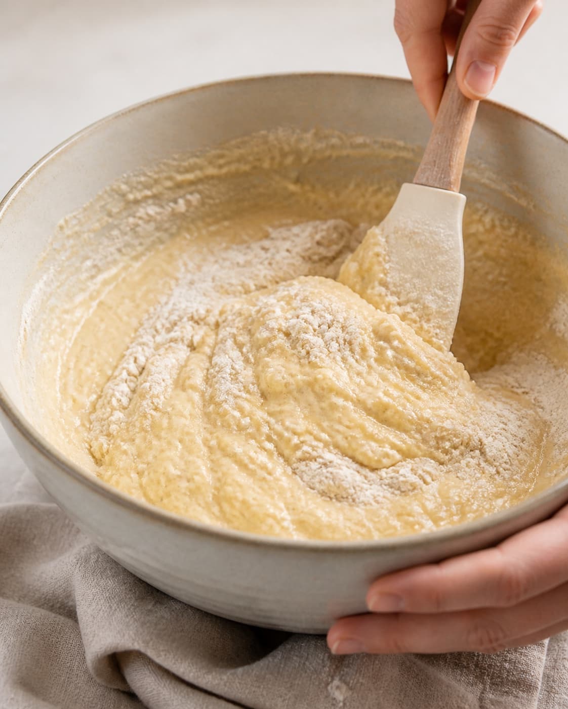 Banana muffin batter being folded gently after whipped butter eggs and mashed banana are combined under tilberedningen af bananmuffins