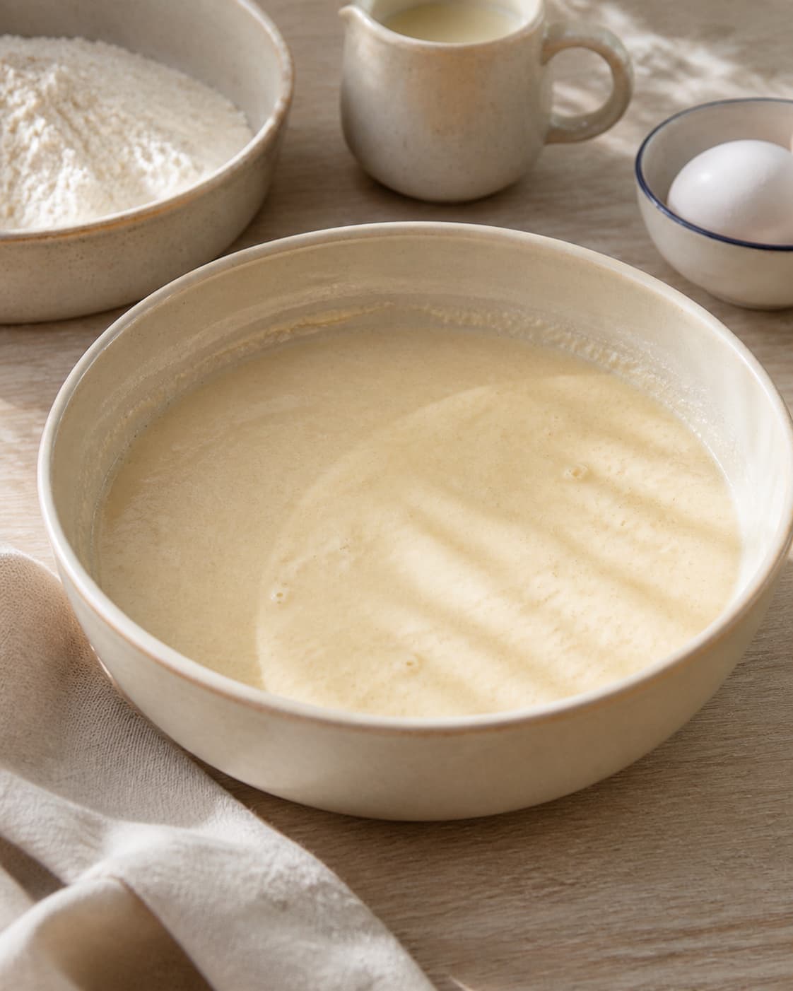 Smooth waffle batter resting briefly with a thick ribbon consistency and small bubbles under tilberedningen af sprøde vafler