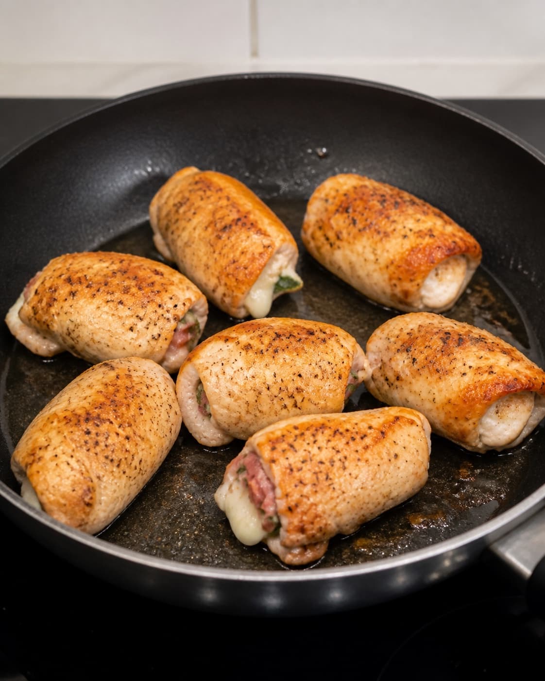 Chicken rolls with a clean chicken exterior browning evenly in olive oil with their seams down under tilberedningen af kyllingeruller med salvie, parmaskinke og mozzarella