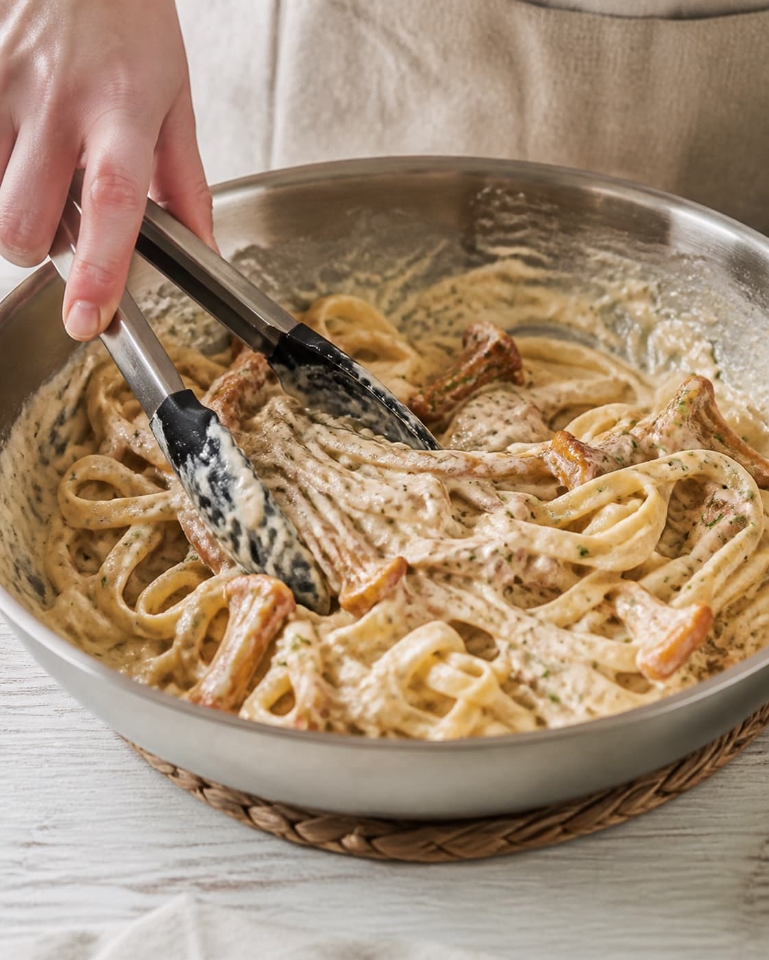 Parmesan and browned chanterelles folded into glossy creamy pasta off strong heat under tilberedningen af pasta med kantareller og fløde
