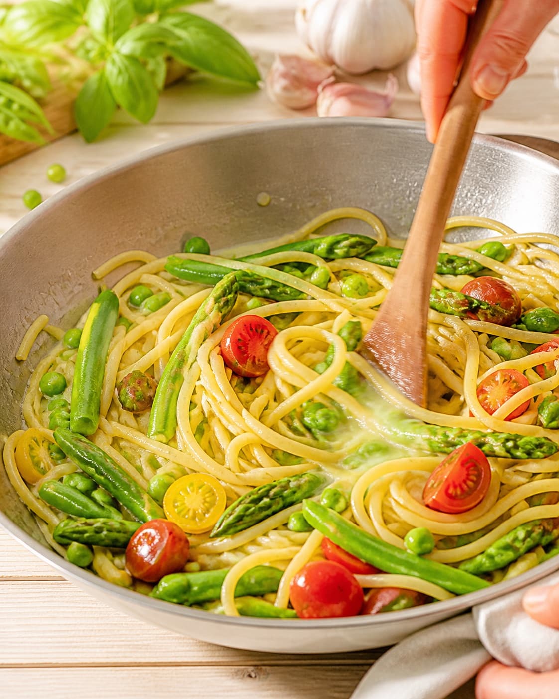 Al dente pasta tossed with peas blistered tomatoes and a little starchy cooking water under tilberedningen af sommerpasta med ærter og tomat