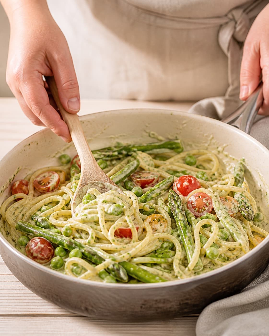 Parmesan lemon zest and juice emulsified into pea tomato pasta off direct heat under tilberedningen af sommerpasta med ærter og tomat