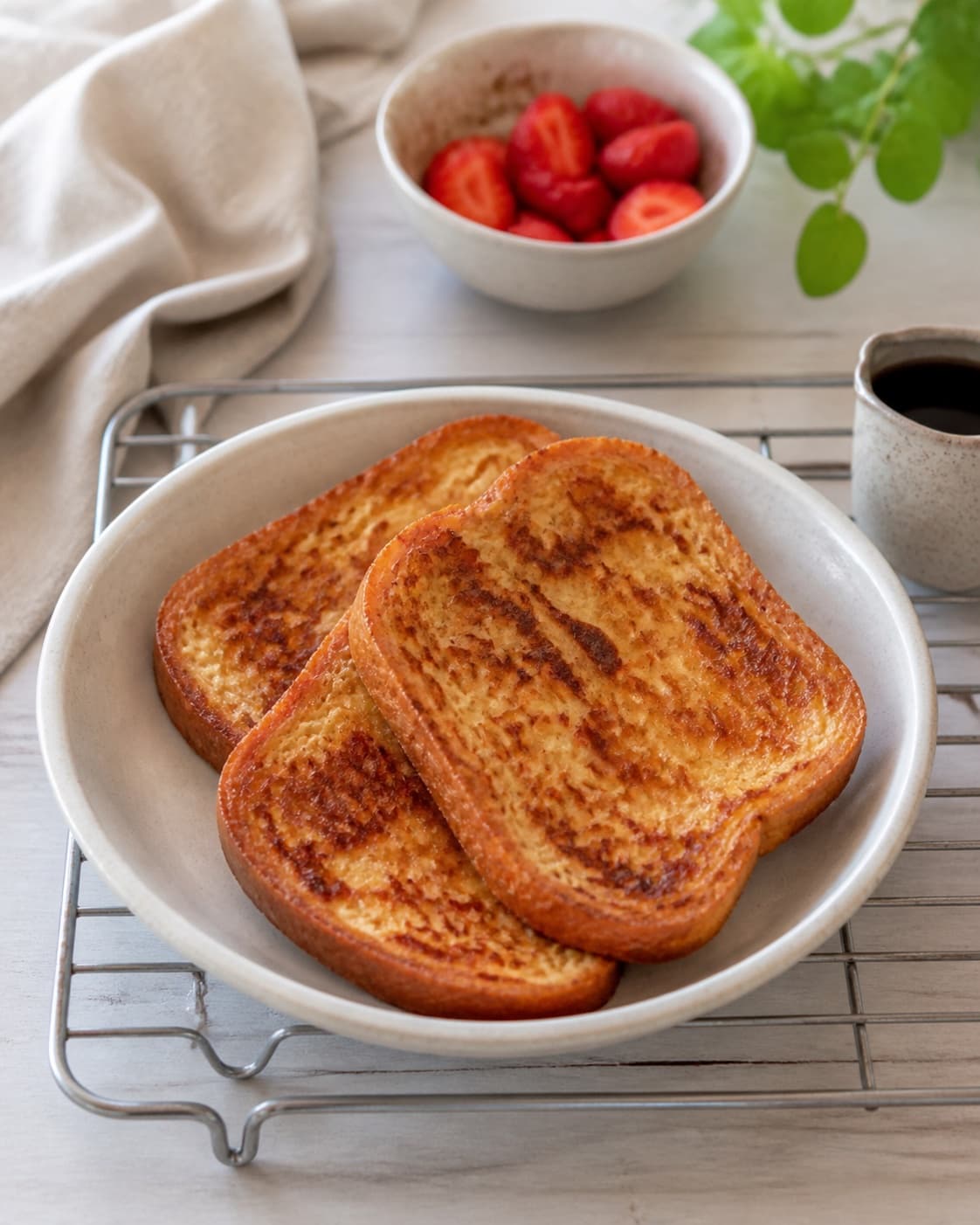 Golden French toast resting briefly on a rack before immediate warm serving under tilberedningen af arme riddere