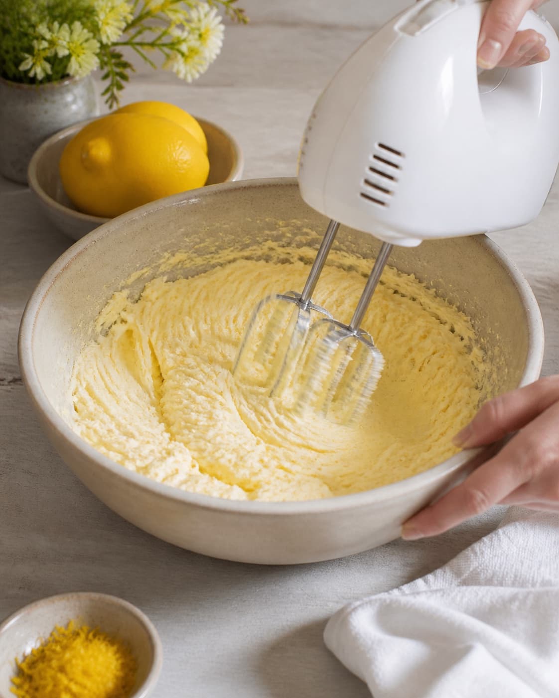 Butter sugar and lemon zest being whipped pale before eggs are added one by one under tilberedningen af saftig citronmåne med citronglasur
