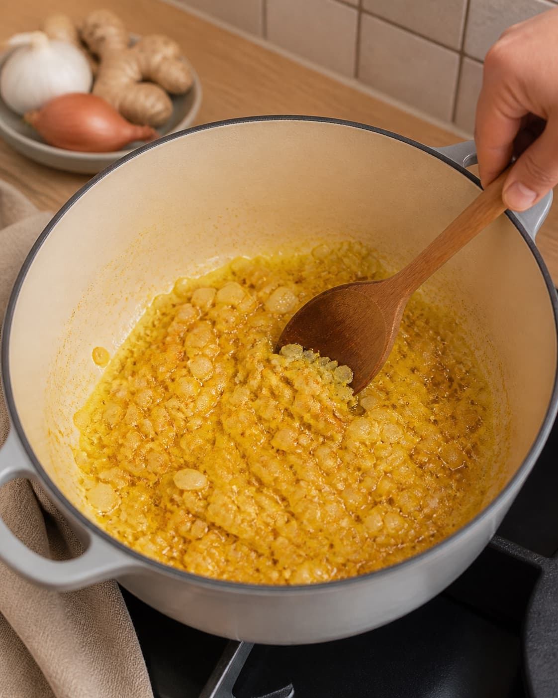 Soft onion garlic ginger curry and turmeric blooming gently in oil in the same pot under tilberedningen af kylling i tomat, karry og kokos