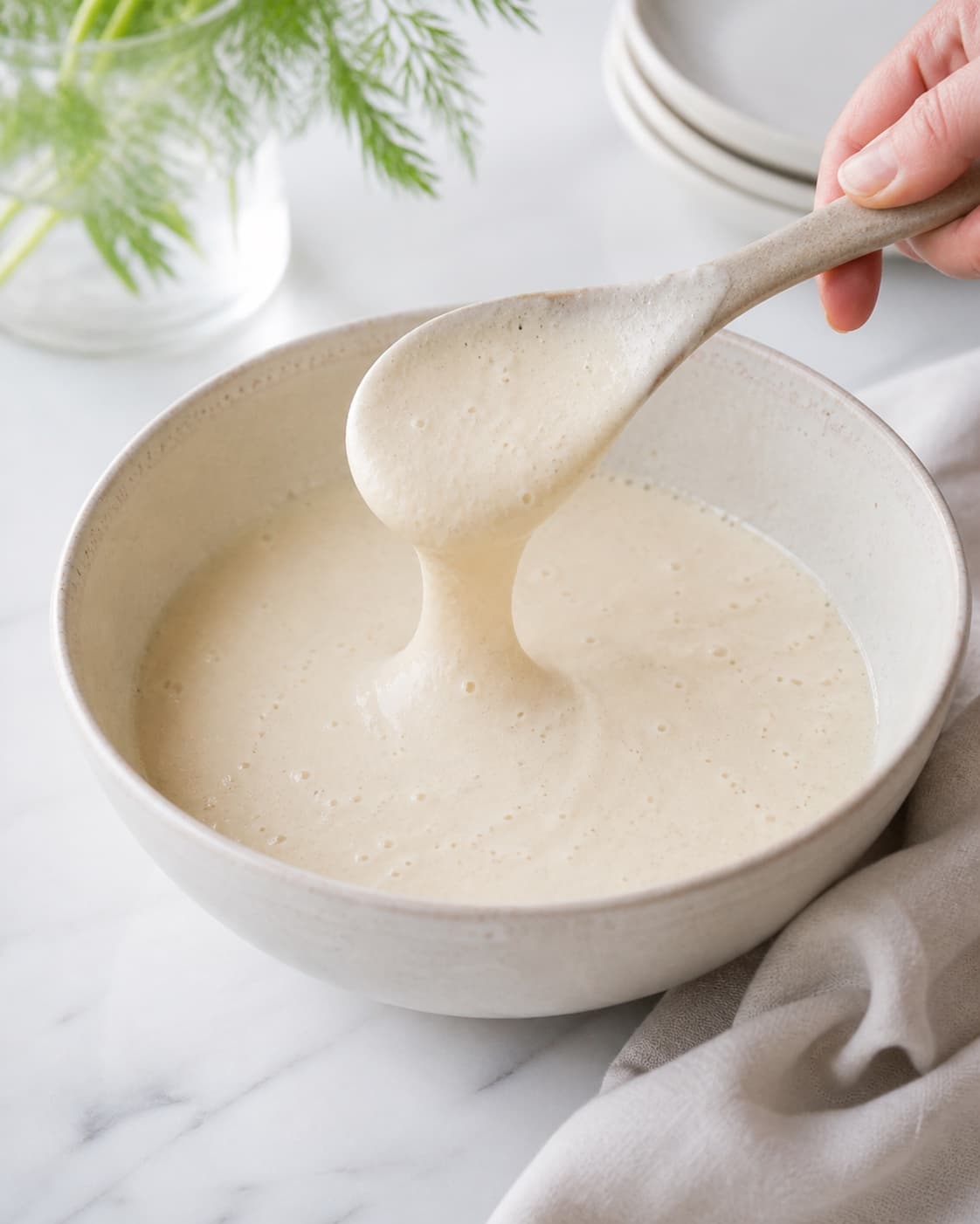 Rested blini batter with small bubbles and a thick spoonable consistency under tilberedningen af blinis med stenbiderrogn
