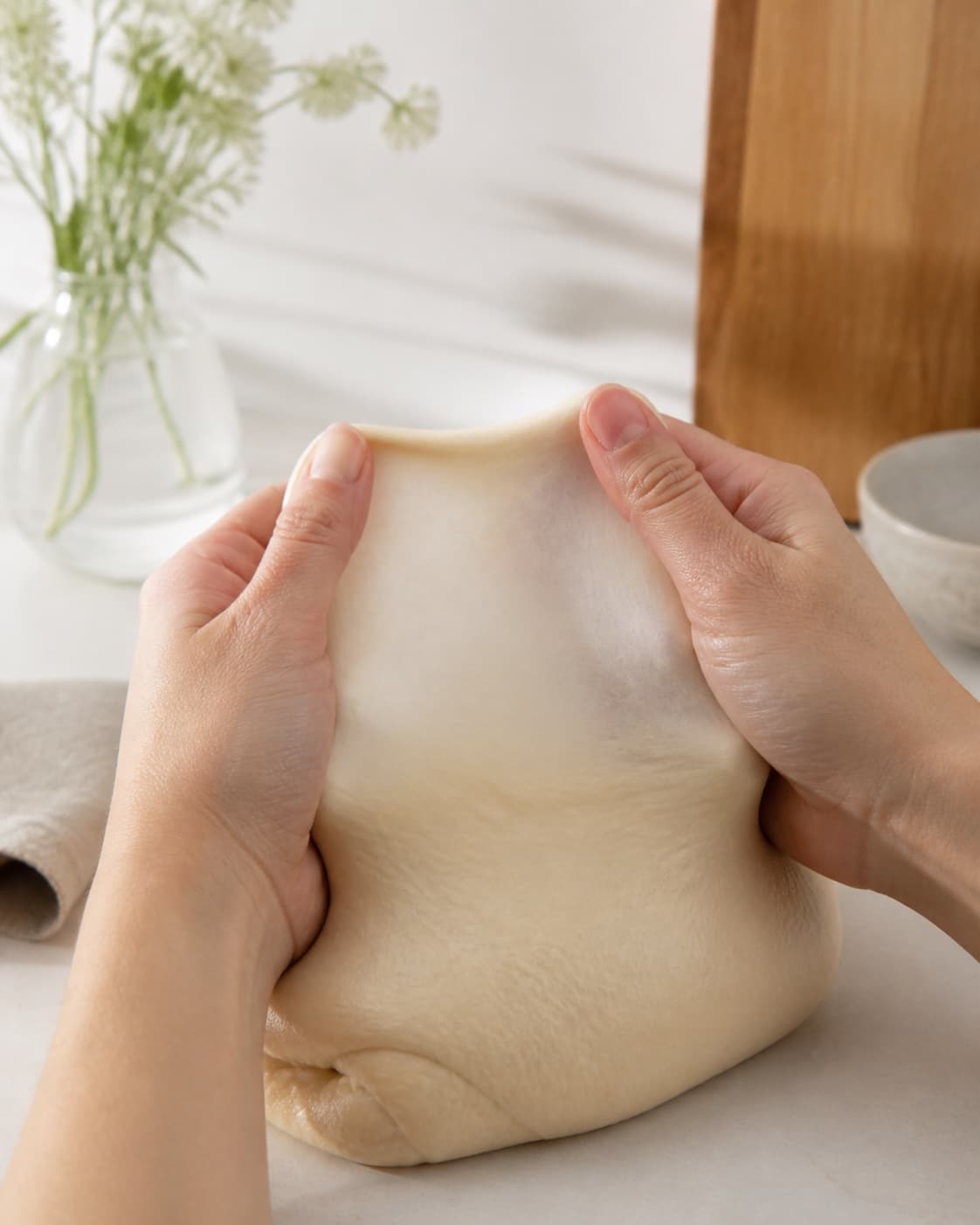 Smooth elastic seedless dough being kneaded to a thin windowpane under tilberedningen af babyvenlige boller uden kerner