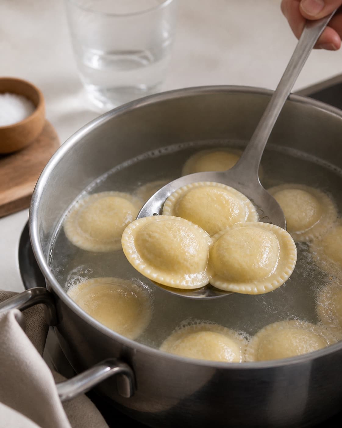 Fresh cheese ravioli gently simmering intact before being lifted with a slotted spoon under tilberedningen af ravioli med gorgonzolasauce