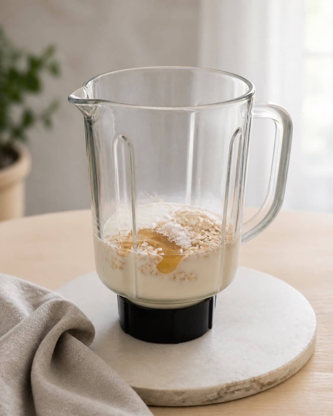 Yoghurt milk oats honey vanilla and salt resting together in a blender jug, no blueberries banana or finished smoothie under tilberedningen af blåbærsmoothie