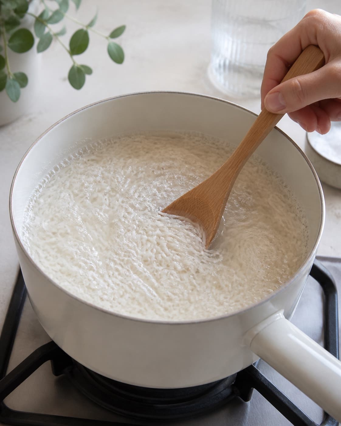 Rinsed white rice and measured water reaching one even boil in a saucepan, stirred exactly once, no lid and no finished rice under tilberedningen af ris – kogetid